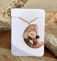 a necklace with a pink flower on it